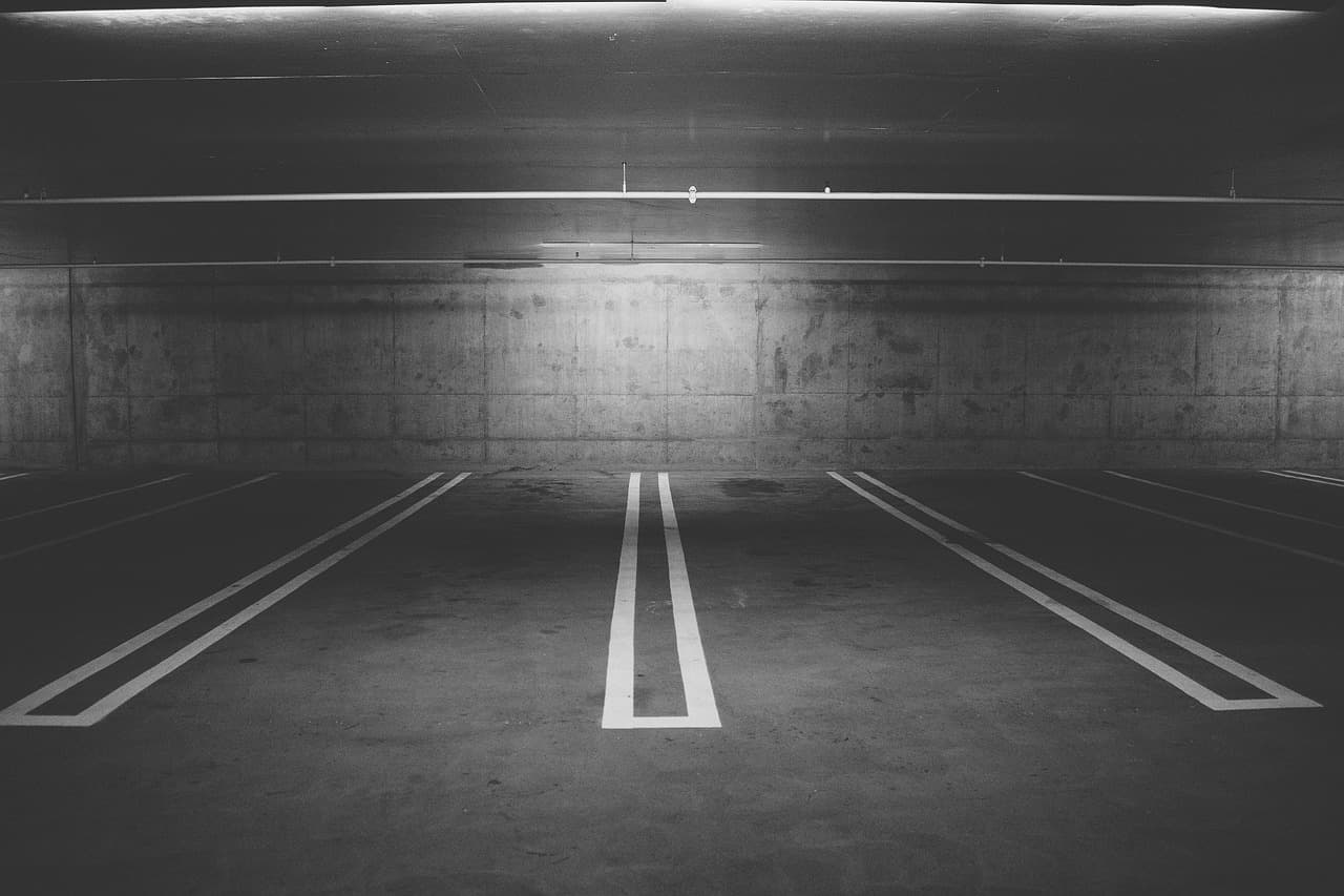 Two empty bays marked out in white paint on a concrete floor